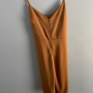 NWOT rust coloured tie-waist jumpsuit w/ button detailing on bodice. Never worn